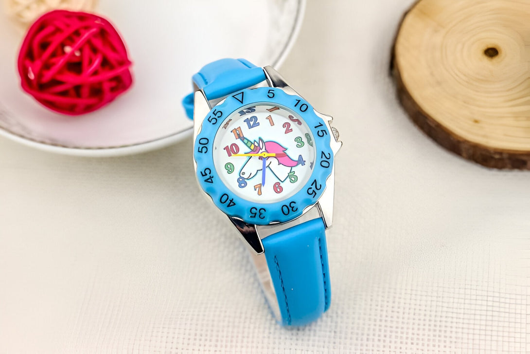 Une montre analogique à quartz avec un bracelet en cuir bleu et un cadran coloré représentant une licorne.