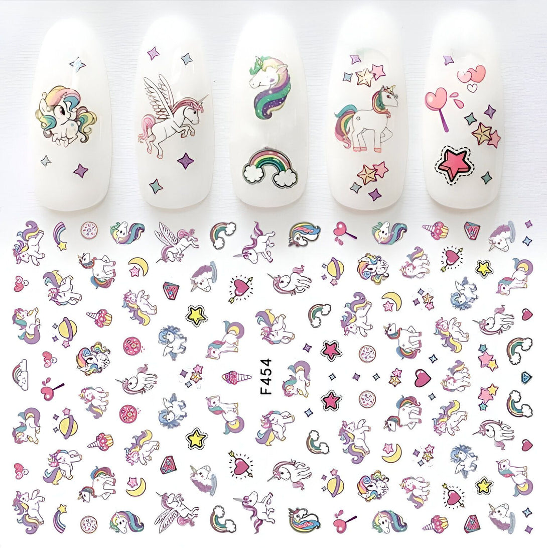Autocollants pour ongles avec des motifs d'unicorne et d'étoiles, disposés sur une feuille et appliqués sur des ongles en gel blanc. Des arcs-en-ciel et des cœurs colorés ajoutent une touche fantaisiste. Idéal pour une manucure ludique et créative., 45501134668031 | Licorne Shop
