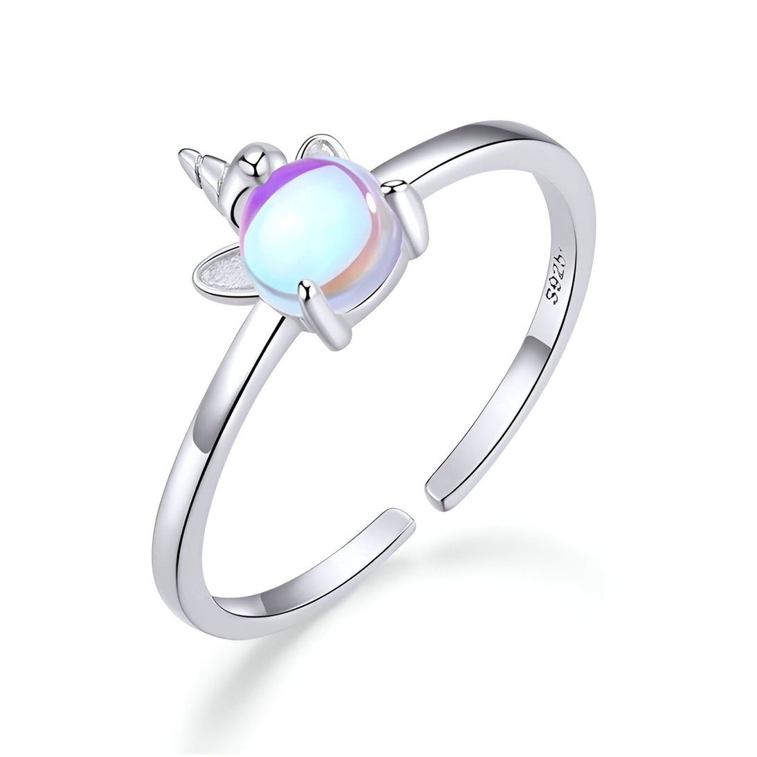 Une bague en argent avec une pierre précieuse opale blanche et rose en forme de licorne.