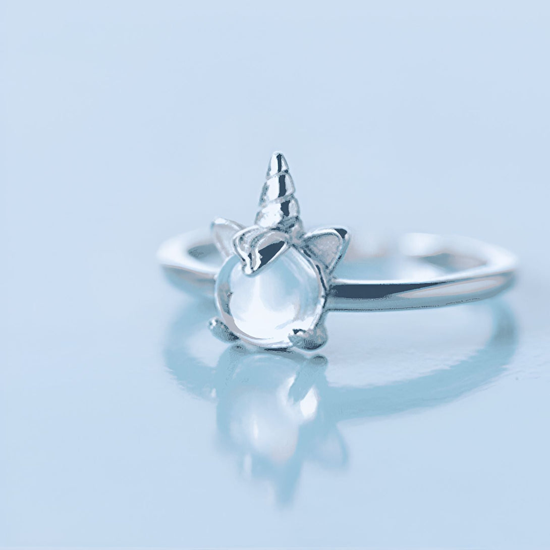 Bague argentée avec un motif de licorne, présentant une petite corne spirale et des oreilles pointues, avec une pierre lumineuse au centre. Bijou fantaisie pour les amoureux des créatures mythiques., 45501845438719,45501845471487,45501845504255,45501845537023,45501845569791,45501845602559,45501845635327,45501845668095,45501845700863,45501845733631,45501845766399,45501845799167,45501845831935,45501845864703,45501845897471 | Licorne Shop