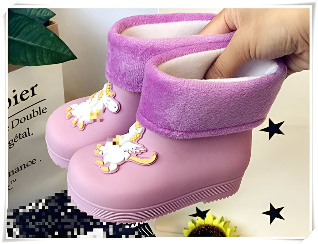 Paire de bottes de pluie roses pour enfants, décorées avec des motifs de licornes. L'intérieur est doublé de fourrure blanche et le bord est en peluche violette. Une main vérifie la douceur de la doublure., 45501215703295,45501215736063,45501215768831,45501215801599,45501215834367,45501215867135,45501215899903,45501215932671,45501215965439 | Licorne Shop