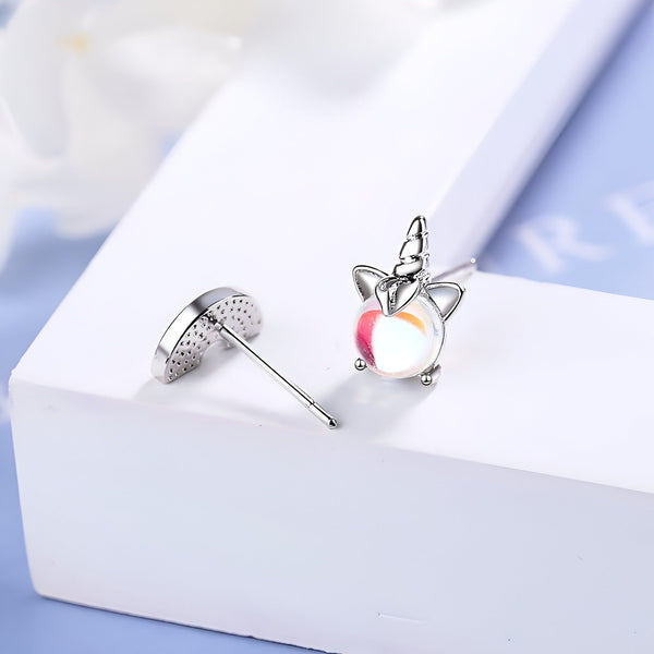 Une paire de boucles d'oreilles en argent sterling avec des zircons cubiques. Les boucles d'oreilles sont en forme de licorne avec une crinière et une queue arc-en-ciel.