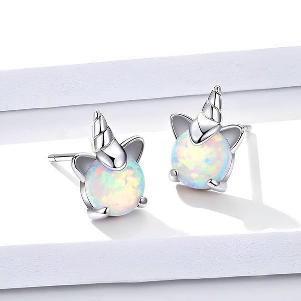 Une paire de boucles d'oreilles en argent avec des pierres précieuses en forme de licorne.