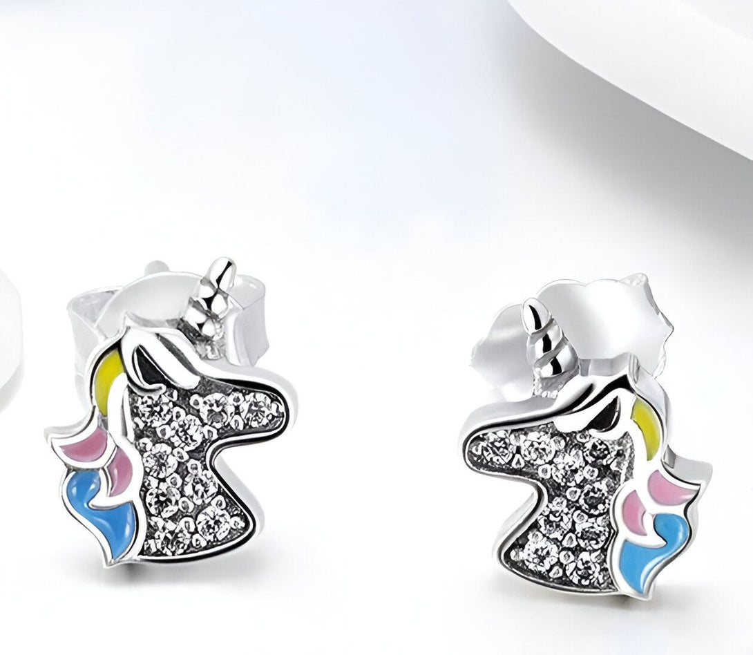 Une paire de boucles d'oreilles en forme de licorne en argent sterling 925. Les licornes ont une crinière et une queue multicolores. Les boucles d'oreilles sont serties de zircons cubiques transparents.