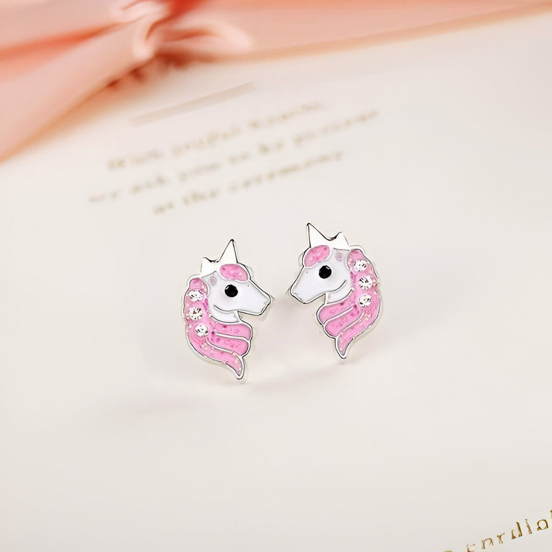 Une paire de boucles d'oreilles en forme de licorne rose et blanche avec des cristaux.