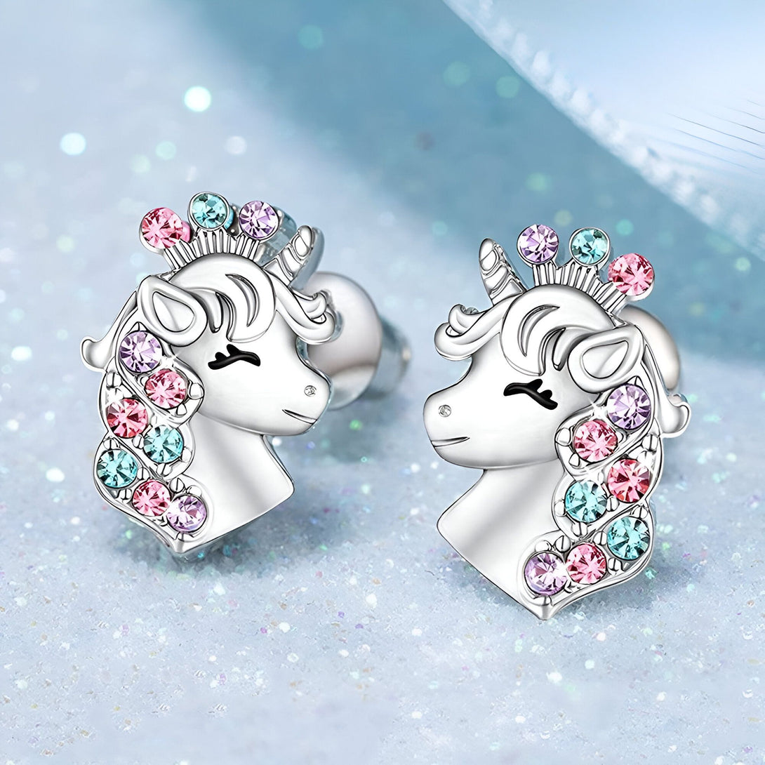 Une paire de boucles d'oreilles en forme de licorne en argent avec des cristaux roses, bleus et violets.