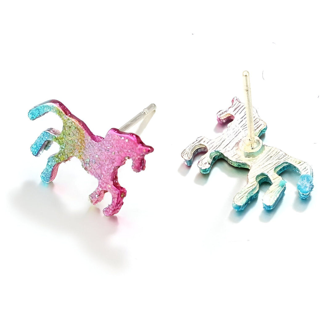Une paire de boucles d'oreilles en forme de licorne. Les licornes sont roses et bleues avec des paillettes.