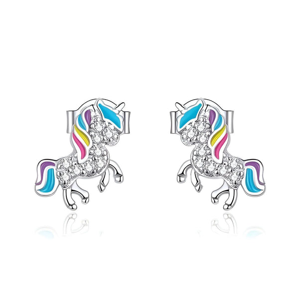 Une paire de boucles d'oreilles en argent avec des licornes. Les licornes sont colorées avec de l'émail et ont des cristaux sur le corps.