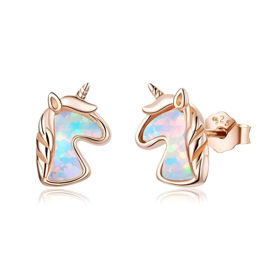 Une paire de boucles d'oreilles en forme de licorne en or rose avec des pierres précieuses blanches.