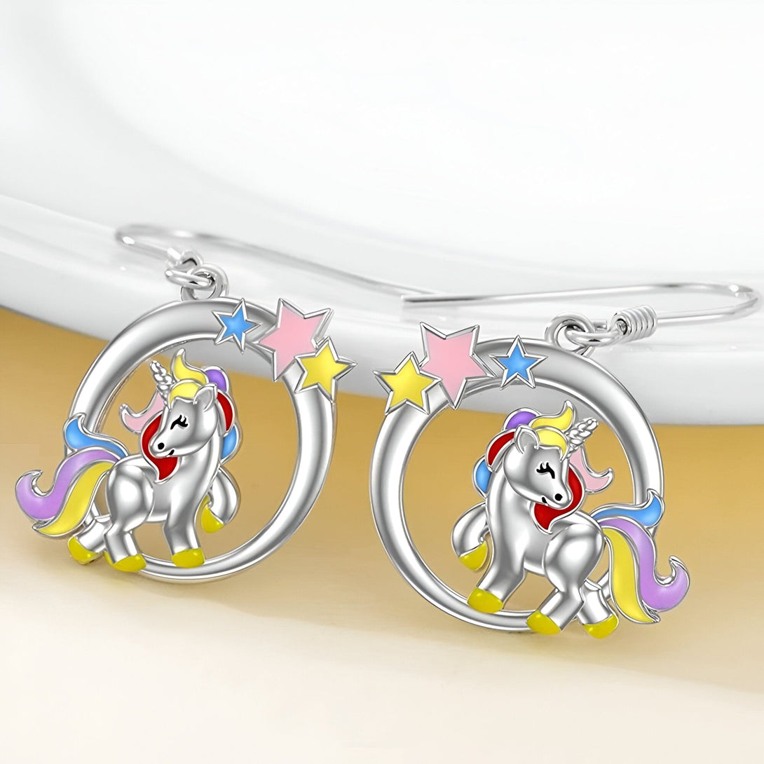 Une paire de boucles d'oreilles en forme de licorne en argent avec des étoiles colorées.