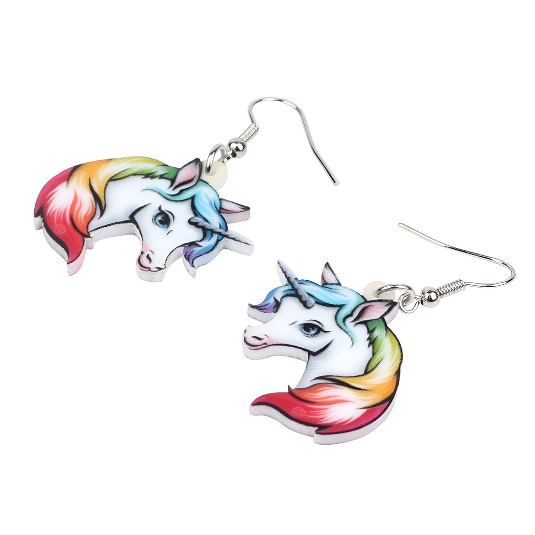 Une paire de boucles d'oreilles en forme de licorne. Les licornes sont blanches avec une crinière et une queue arc-en-ciel. Les boucles d'oreilles sont en plastique et ont un fermoir en métal.