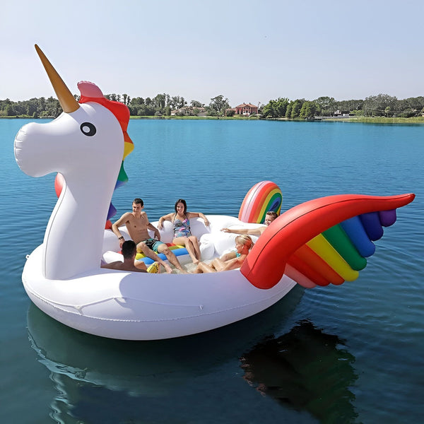 Groupe d'amis se détendant sur un grand flotteur de piscine gonflable en forme de licorne blanche avec des ailes arc-en-ciel sur un lac bleu par une journée ensoleillée. Amusement estival et style de vie aquatique., 45501230317823 | Licorne Shop