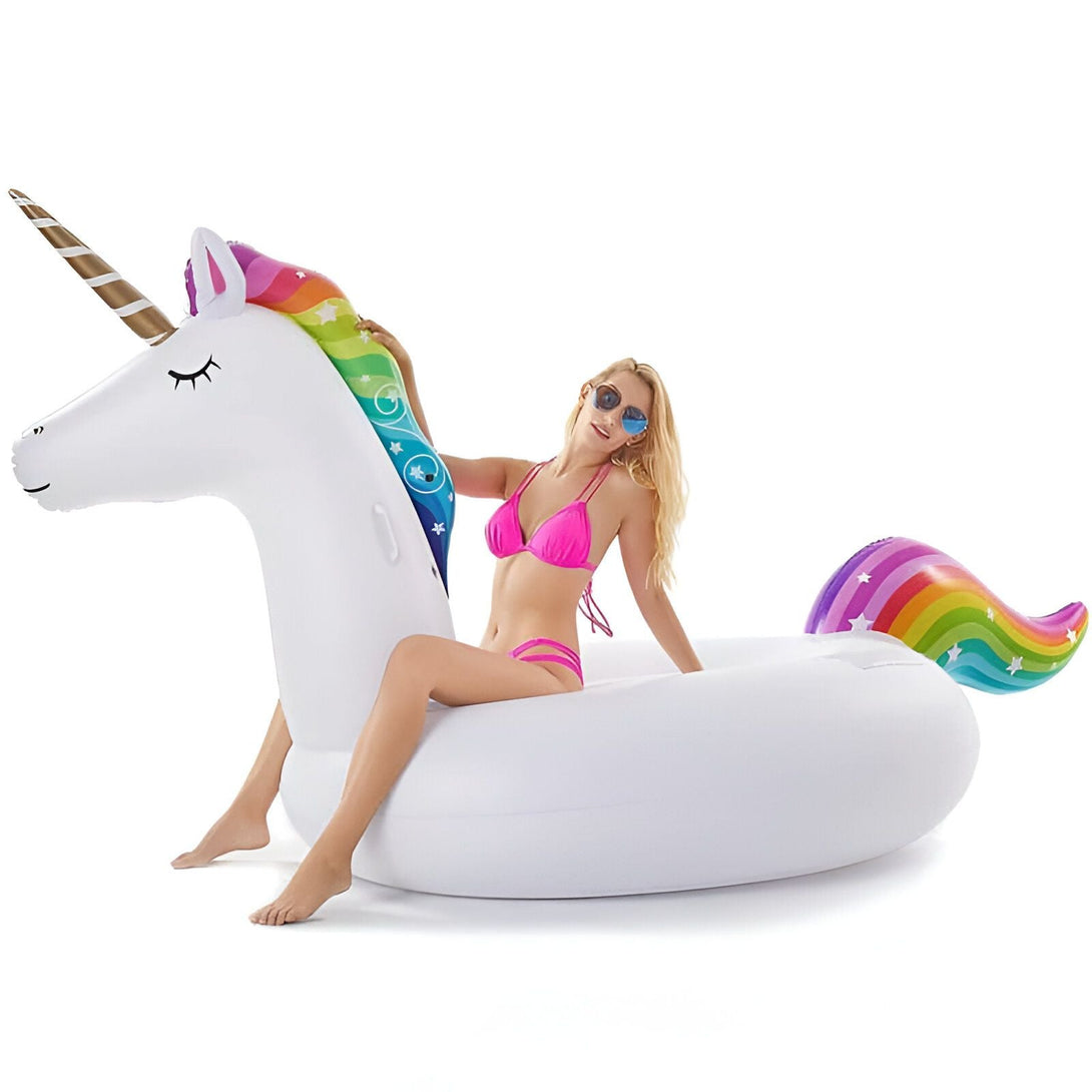 Femme en bikini rose sur une bouée gonflable licorne blanche avec crinière et queue arc-en-ciel, et corne dorée. Lunettes de soleil bleues. Idéal pour la piscine ou la plage. Amusant et estival., 45501250470143 | Licorne Shop