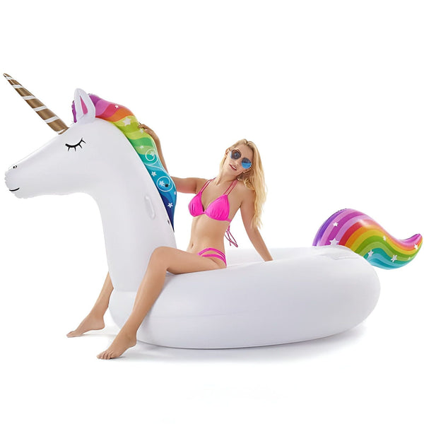 Femme en bikini rose sur une bouée gonflable licorne blanche avec crinière et queue arc-en-ciel, et corne dorée. Lunettes de soleil bleues. Idéal pour la piscine ou la plage. Amusant et estival., 45501250470143 | Licorne Shop