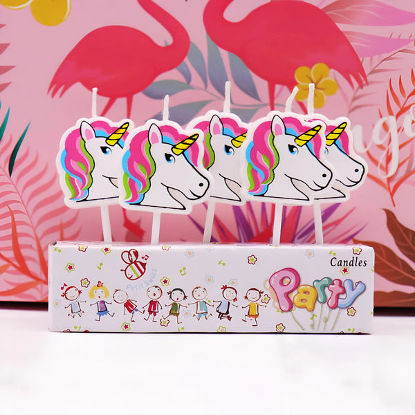 Bougies d'anniversaire décoratives en forme de têtes de licorne colorées. Elles sont présentées dans une boîte avec des motifs enfantins et le mot "Party". En arrière-plan, un papier cadeau rose avec des flamants roses., 45501141188863 | Licorne Shop
