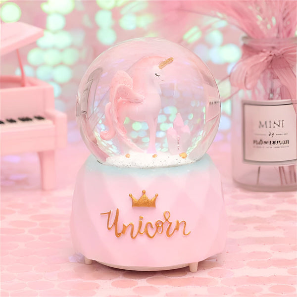 Boule à neige rose avec licorne à l'intérieur. Décoration avec un mini piano, un vase rose et une inscription "Unicorn" avec une couronne. Idéal pour chambre d'enfant ou cadeau fantaisie., 45501133881599 | Licorne Shop