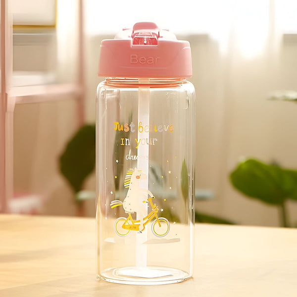 Bouteille d'eau transparente avec bouchon rose. Motif de licorne faisant du vélo et message inspirant "Just believe in your dreams". Accessoire mignon et motivant pour rester hydraté., 45501177463039 | Licorne Shop