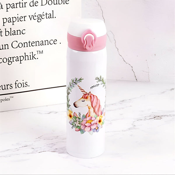 Gourde blanche avec bouchon rose et illustration d'une licorne entourée de fleurs. Bouteille d'eau réutilisable décorée avec un motif féerique, idéale pour les enfants et les adultes. Accessoire tendance et pratique pour rester hydraté., 45501176479999 | Licorne Shop