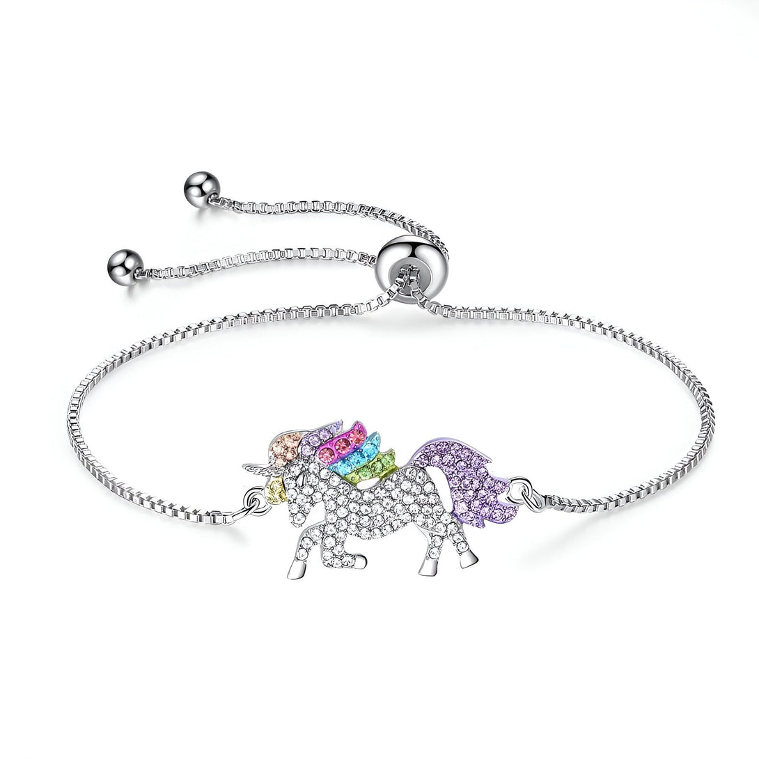 Un bracelet avec une chaîne en argent et un pendentif en forme de licorne. La licorne est sertie de cristaux de différentes couleurs.