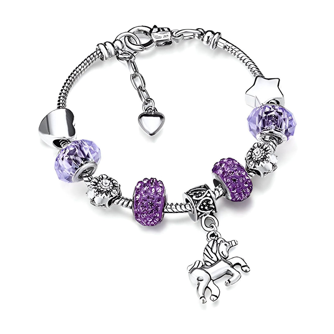 Le bracelet est en argent et possède des perles de couleur mauve. Il y a un pendentif en forme de licorne, un cœur, une étoile et une fleur.