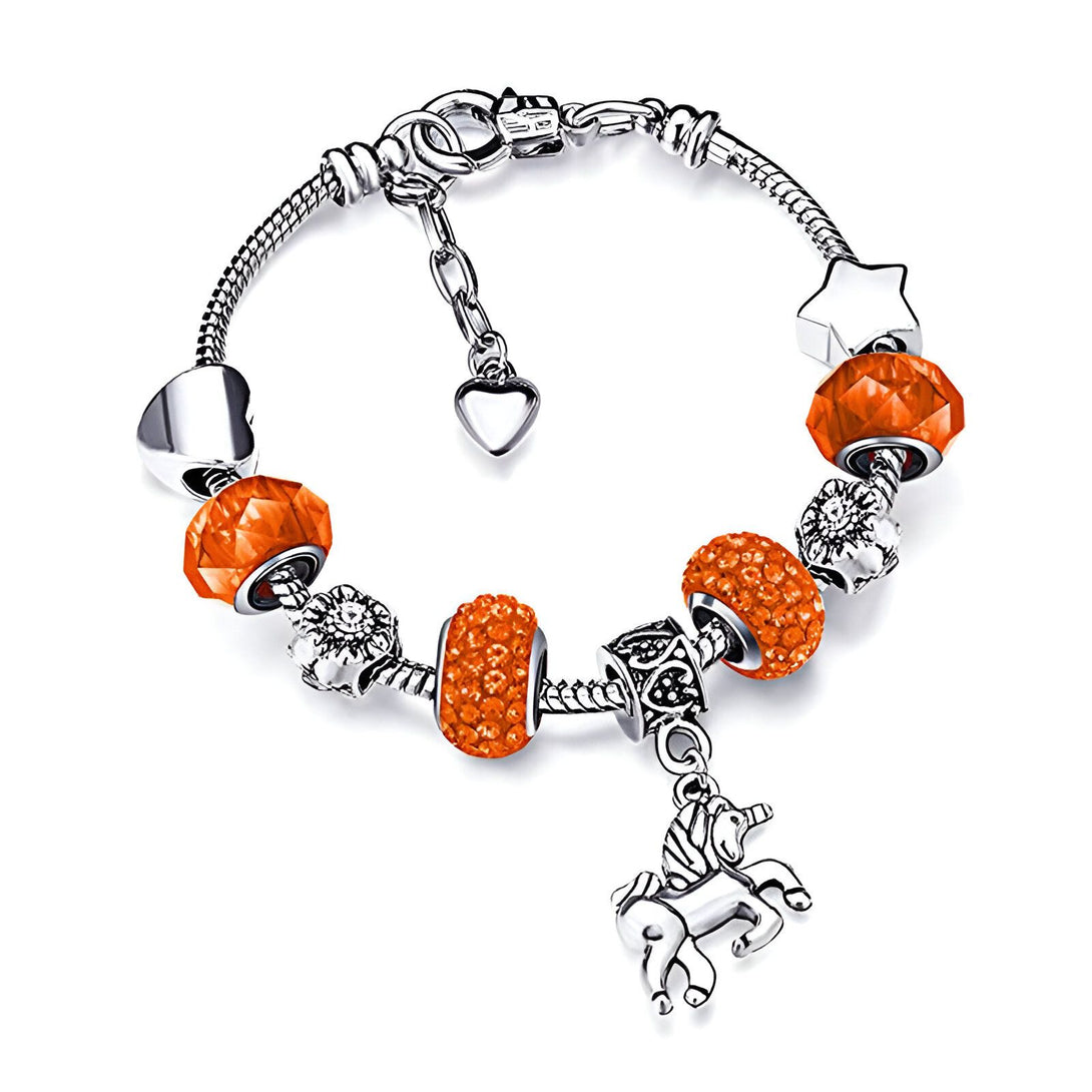 Un bracelet avec des breloques en forme de cœur, d'étoile, de fleur et de licorne. Les breloques sont en métal argenté et les cristaux sont de couleur orange.