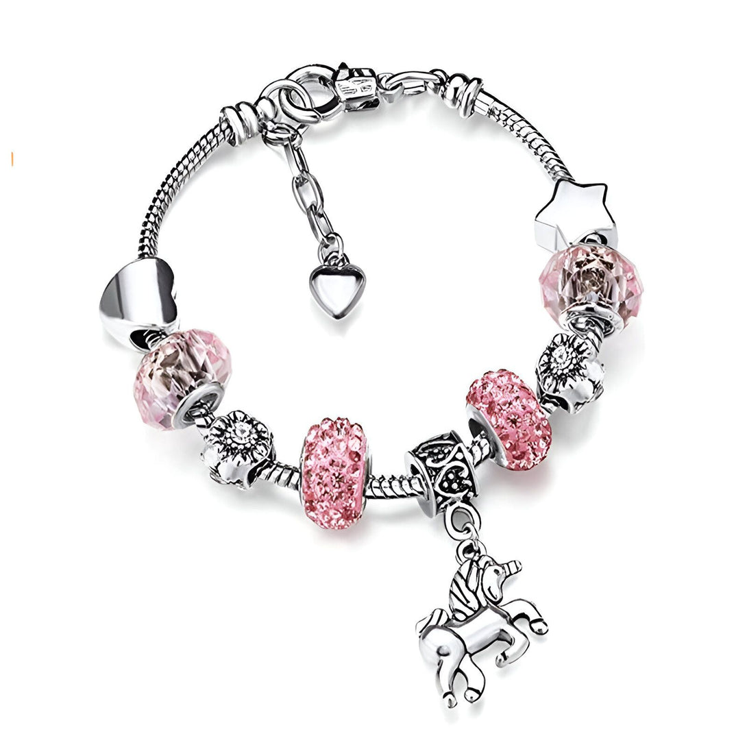 Un bracelet en argent avec des breloques en forme de cœur, de fleur, d'étoile et de licorne. Les breloques sont serties de cristaux roses.