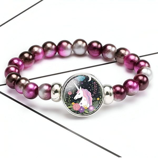 Bracelet élastique avec des perles roses et grises, et un pendentif rond représentant une licorne dans un jardin fleuri., 45501422698751 | Licorne Shop
