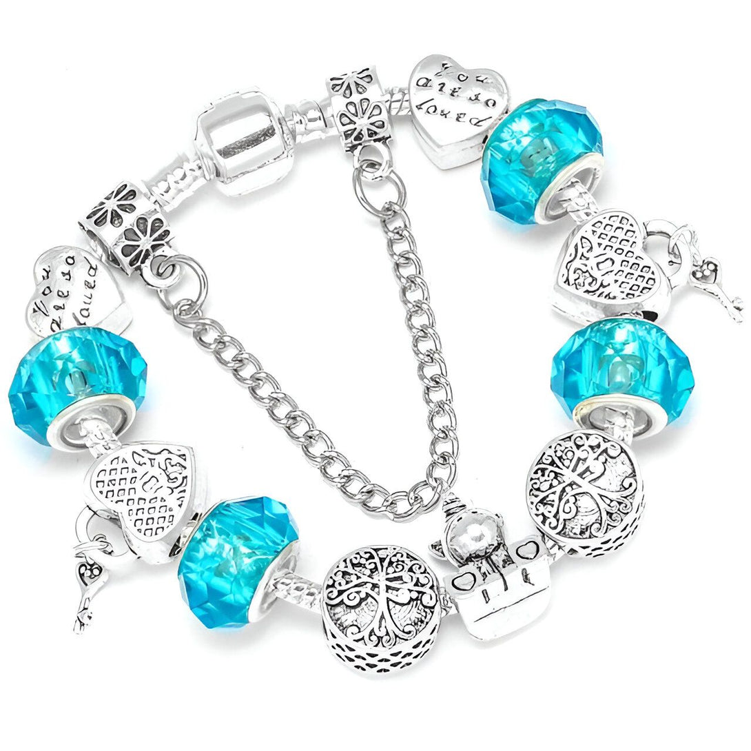 Un bracelet Pandora avec des breloques en forme de cœur, de cadenas, d'arbre de vie et de la phrase "You are so loved". Les breloques sont en argent et les cristaux sont bleu clair.