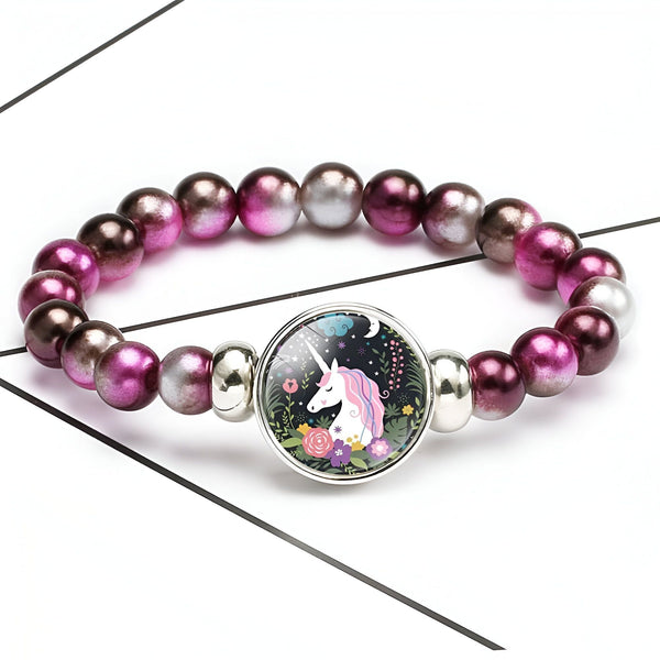Bracelet de perles violettes et argentées avec un pendentif rond représentant une licorne, des fleurs et un ciel étoilé. Bijou fantaisie., 45501400318207 | Licorne Shop