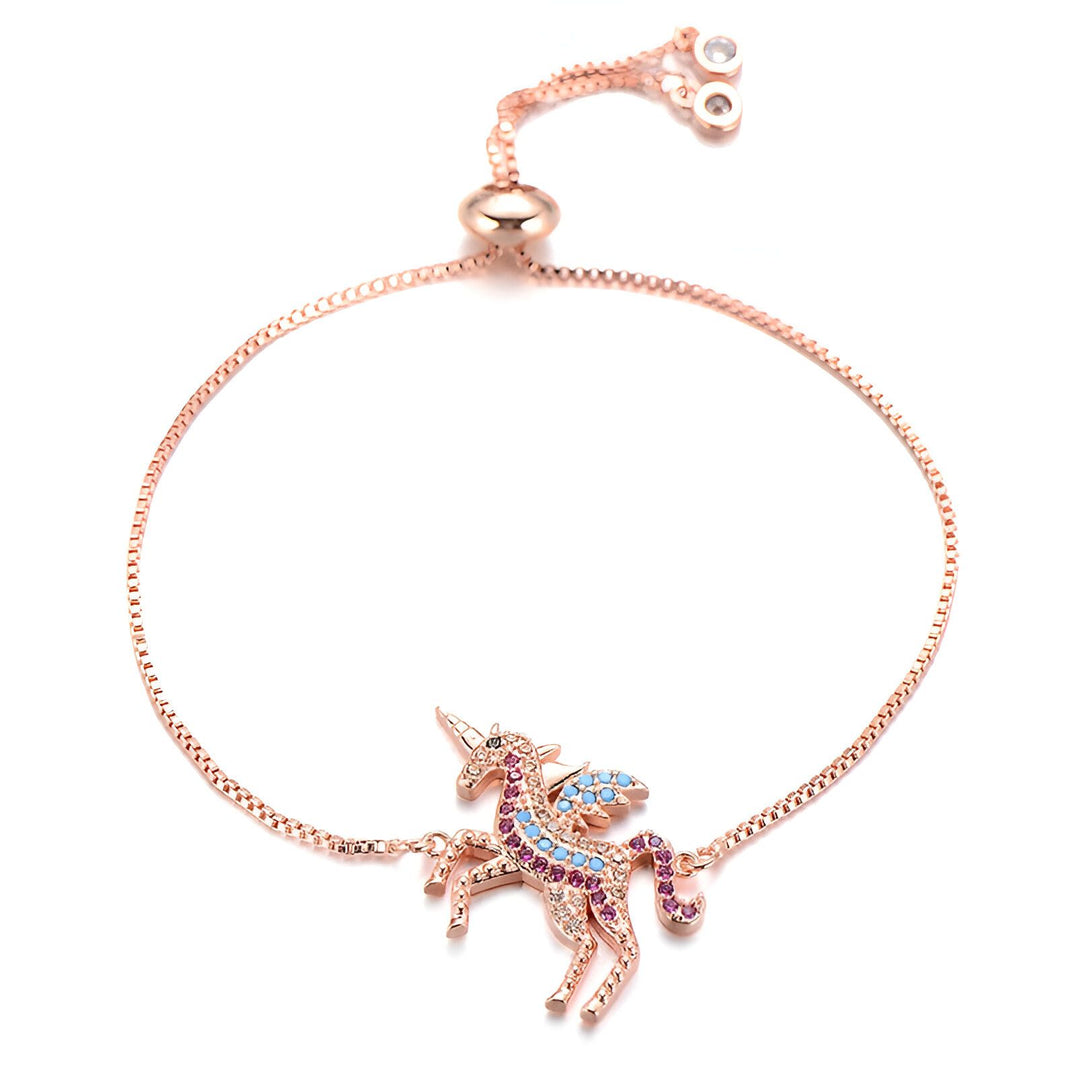 Un bracelet avec une chaîne en or rose et un pendentif licorne. La licorne est sertie de cristaux roses, bleus et violets.