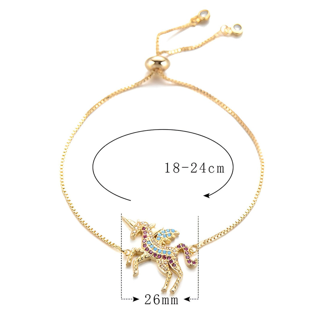 Un bracelet avec un pendentif licorne en plaqué or. La licorne a des ailes et une crinière arc-en-ciel. Le bracelet est réglable de 18 à 24 cm.