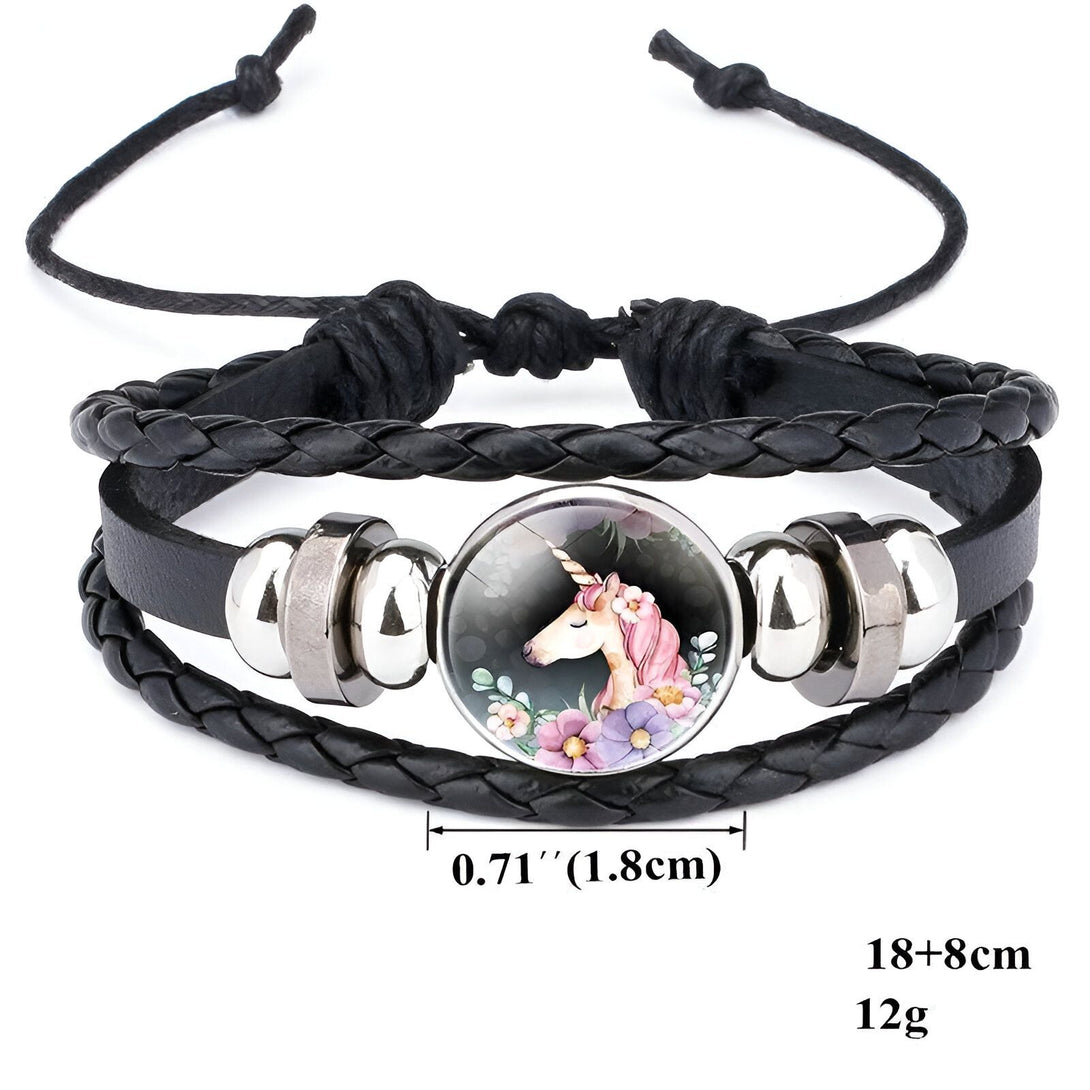 Le bracelet est en cuir tressé noir avec un fermoir en acier inoxydable. Il est orné d'une perle en verre avec une image d'une licorne blanche avec une crinière et une queue roses. La licorne est entourée de fleurs roses, violettes et bleues. Le bracelet mesure 18 cm de long et 8 cm de large. Il pèse 12 grammes.