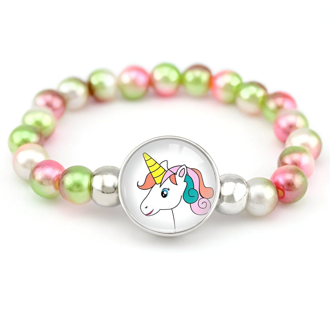 Un bracelet avec des perles roses et vertes et un pendentif en forme de licorne. La licorne a une crinière et une queue arc-en-ciel.