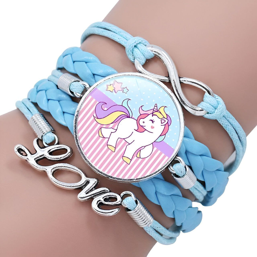 Un bracelet en cuir bleu avec un pendentif en forme de licorne. La licorne est blanche avec une crinière et une queue arc-en-ciel. Elle est entourée d'étoiles et de cœurs. Le bracelet est également décoré d'un signe de l'infini et du mot "love".