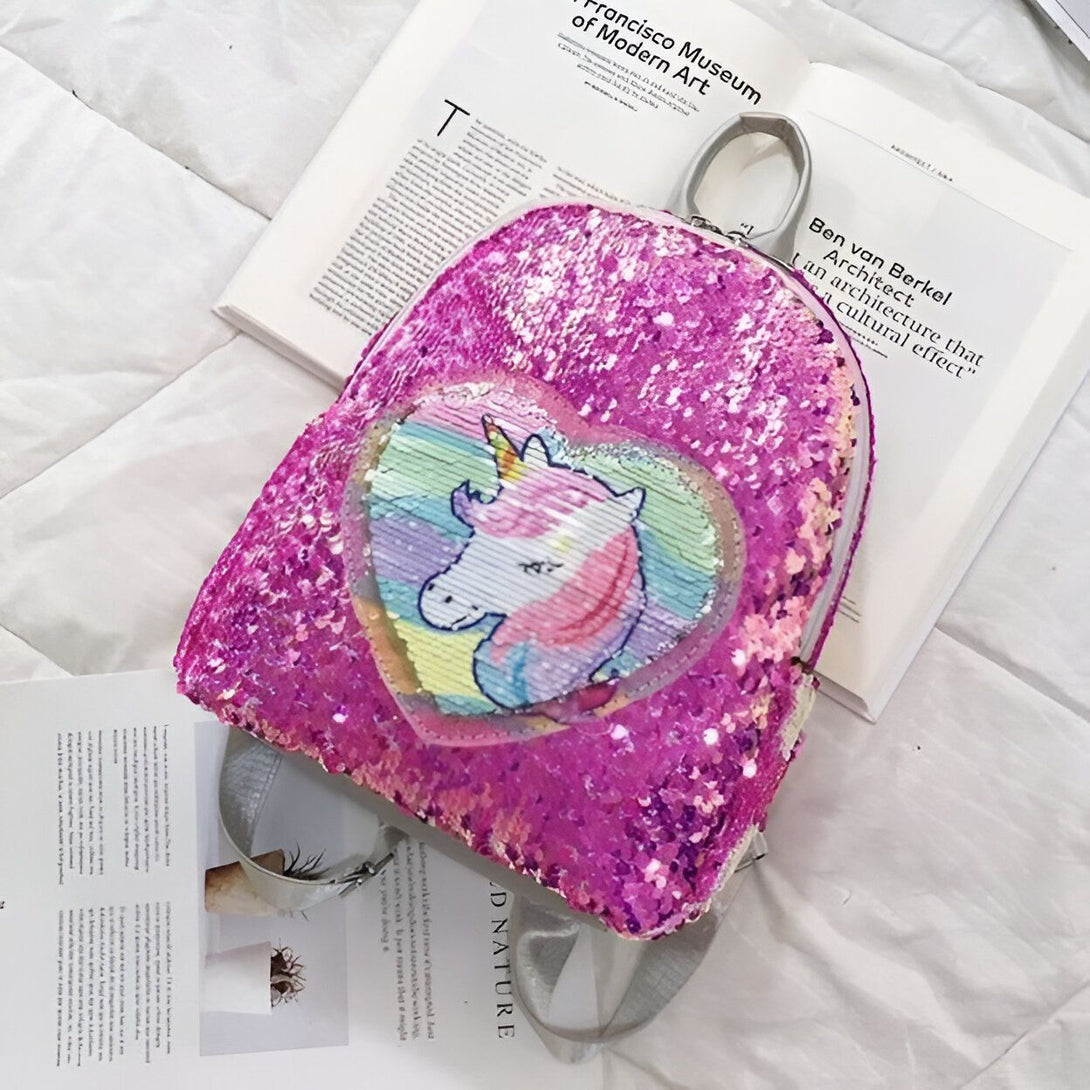 Un sac à dos rose à paillettes avec une image de licorne arc-en-ciel.