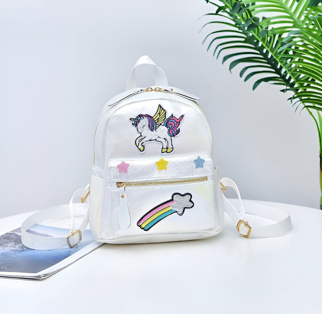 Un sac à dos blanc avec une image de licorne ailée et une étoile filante arc-en-ciel.