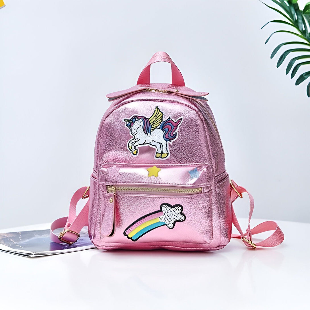 Un sac à dos rose avec une licorne ailée et une étoile filante arc-en-ciel.