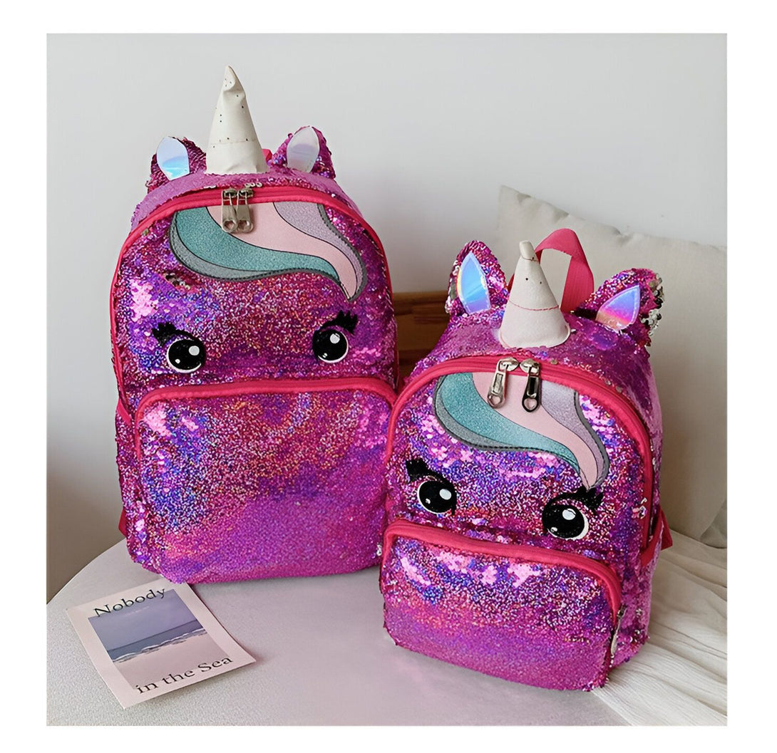 Deux sacs à dos à paillettes roses en forme de licorne avec des yeux et une corne.