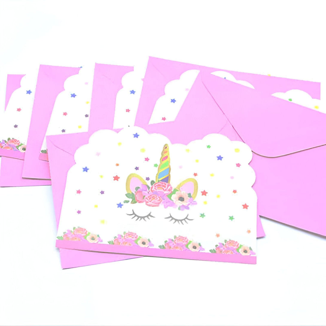 Gros plan de plusieurs cartes et enveloppes roses. Les cartes représentent une tête de licorne blanche ornée de fleurs, d'étoiles multicolores et d'un fond festonné. Idéal pour les anniversaires d'enfants ou toute occasion spéciale., 45501112615167 | Licorne Shop
