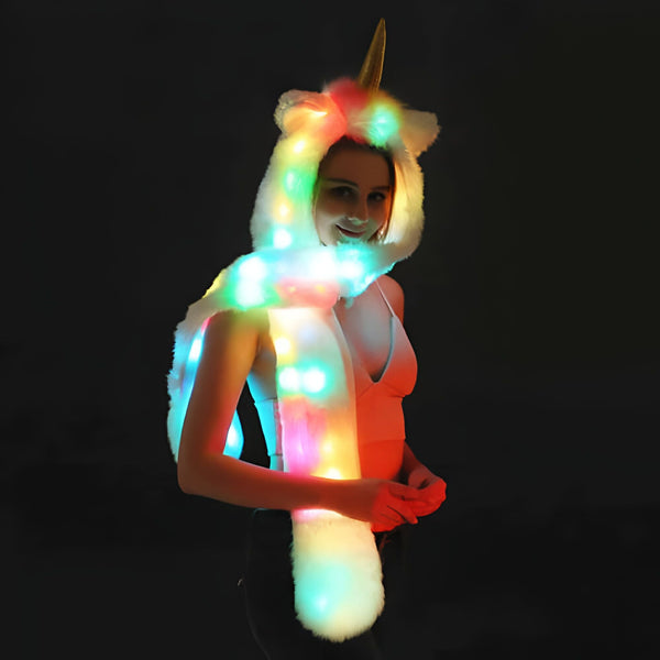Image d'une femme souriante portant un chapeau et une écharpe lumineux en forme de licorne blanche. Le bonnet a une corne dorée et des oreilles blanches. Des lumières colorées illuminent l'ensemble de l'accessoire., 45501619208447 | Licorne Shop