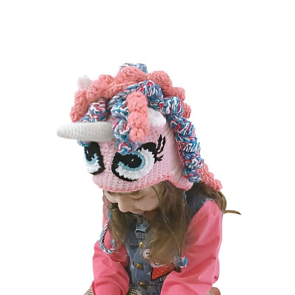 Une fillette porte un bonnet d'hiver rose et bleu en forme de licorne au crochet. Le bonnet a une corne blanche et de grands yeux noirs avec des cils., 45501684023551 | Licorne Shop