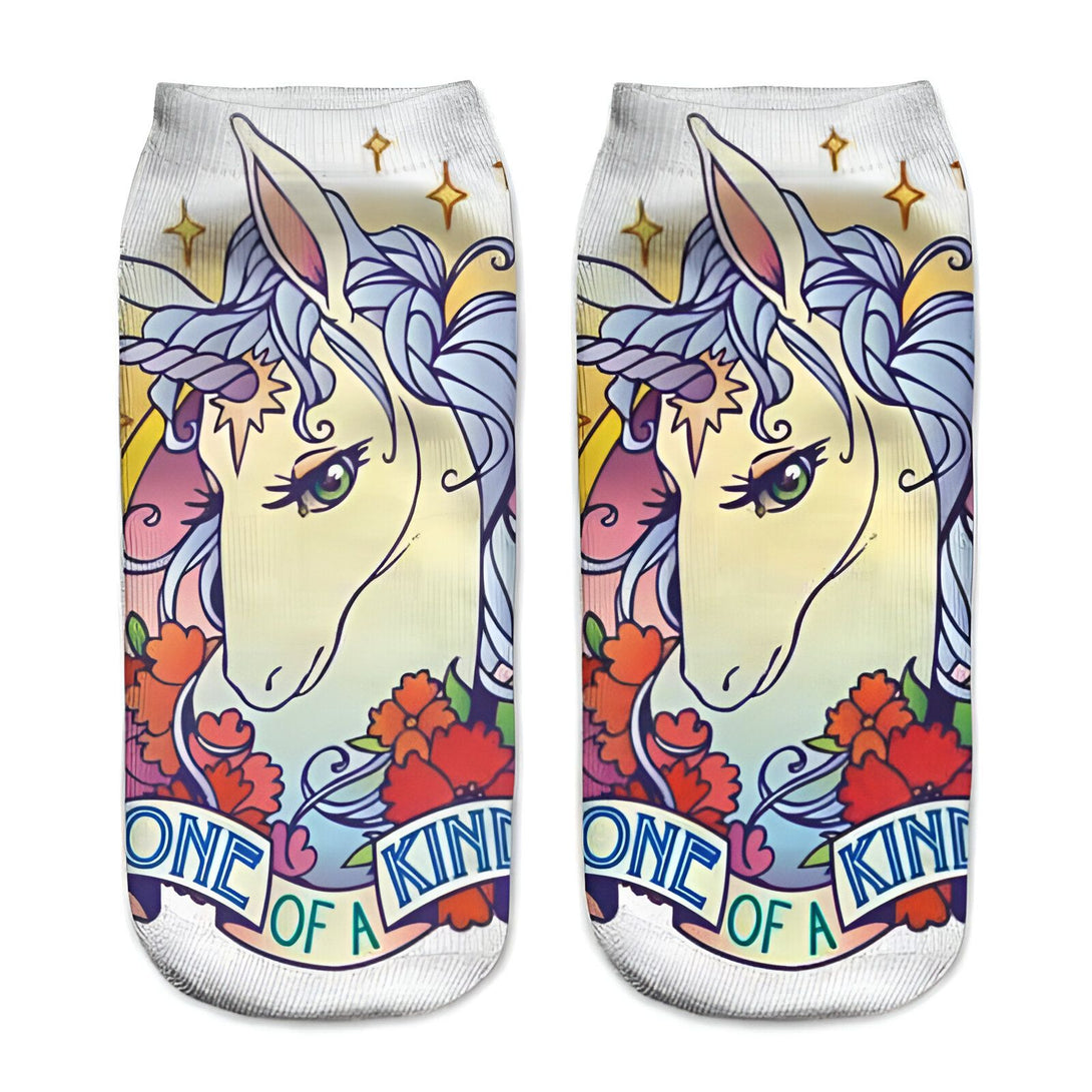 Paire de chaussettes blanches décorées d'une illustration de licorne avec une crinière bleue et des fleurs, portant la mention "One of a kind"., 45502247764223 | Licorne Shop