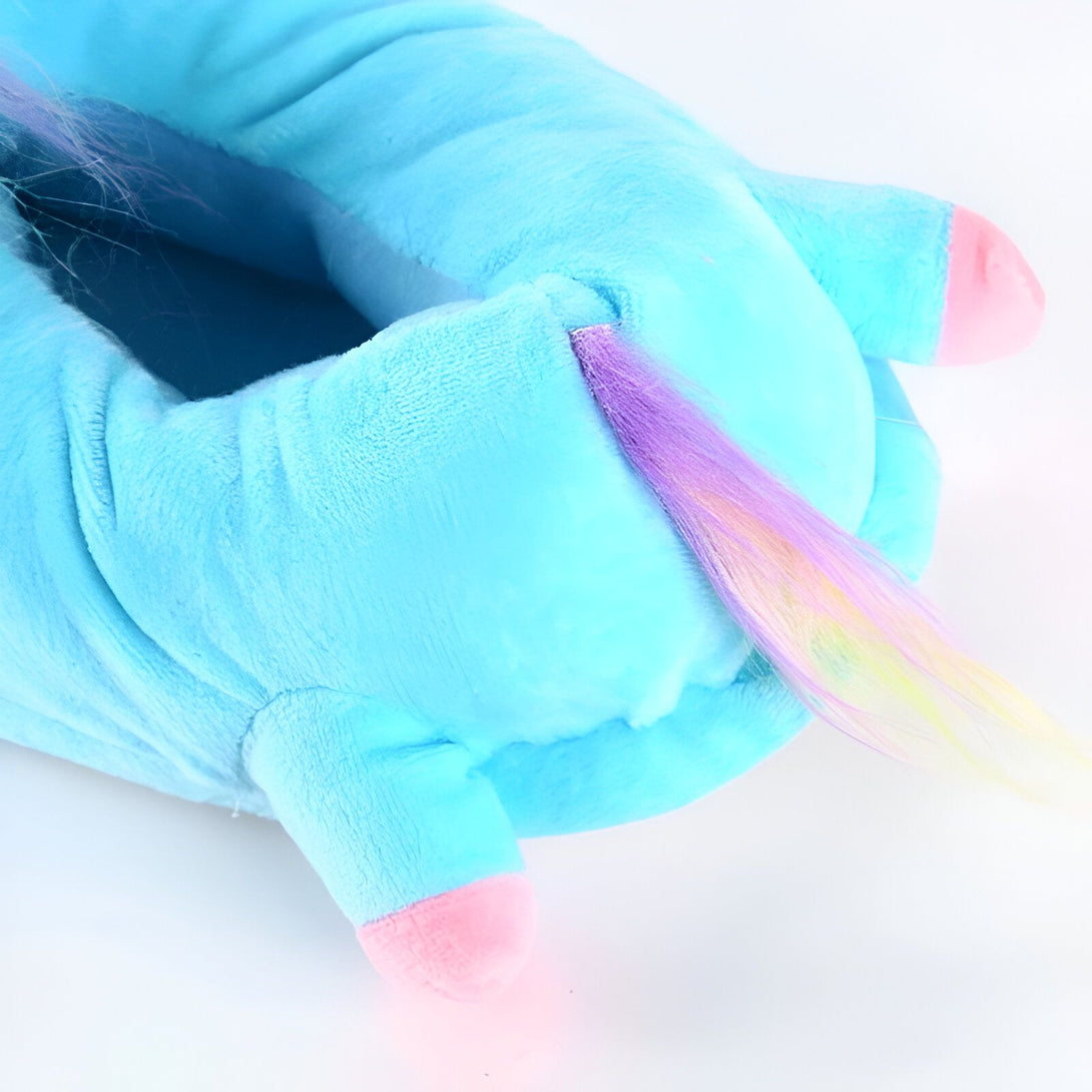 Une peluche licorne bleue avec une crinière et une queue arc-en-ciel.