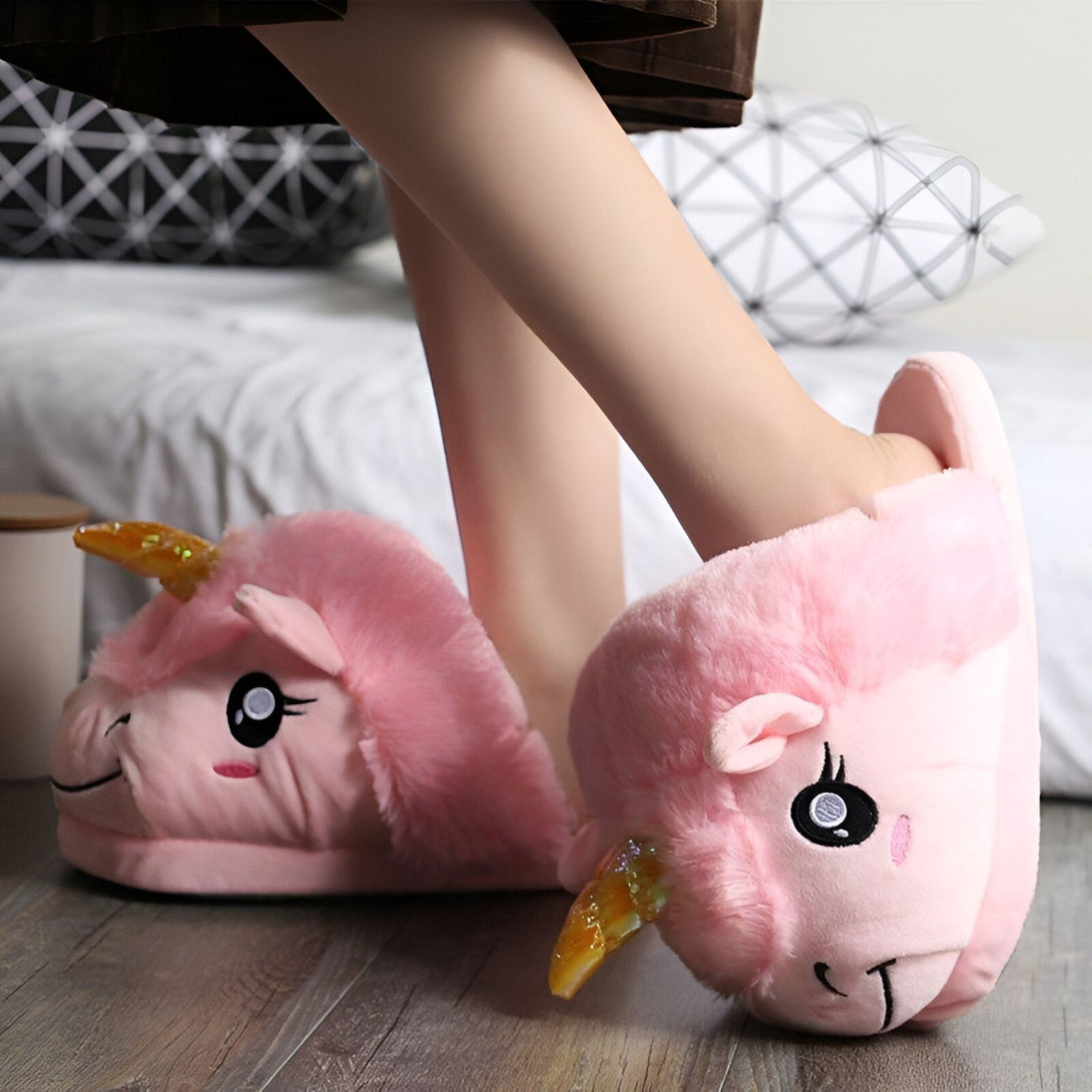 chaussons licorne en peluche rose avec une corne dorée et des yeux bleus