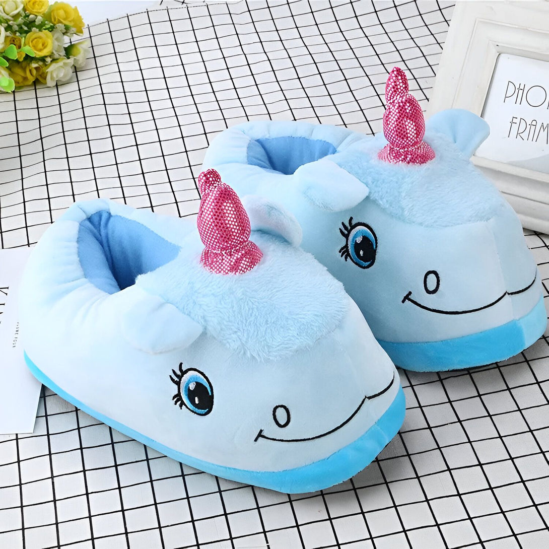 Une paire de pantoufles en peluche bleue en forme de licorne. Les pantoufles ont une semelle antidérapante et sont très confortables à porter.