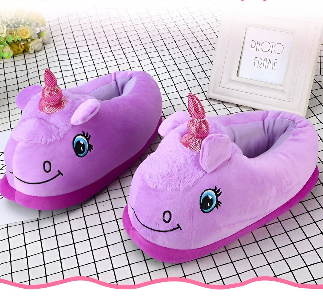 Une paire de pantoufles licorne violettes avec une corne et des yeux.