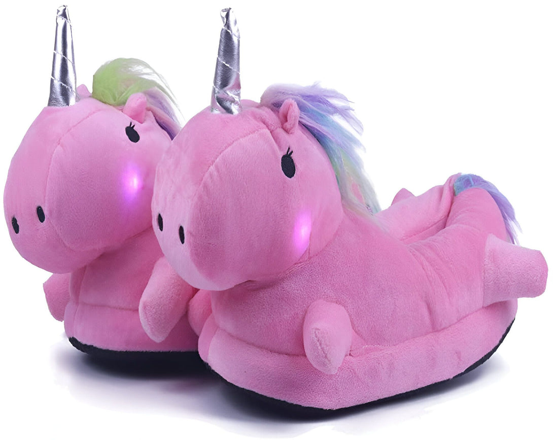 Une paire de pantoufles licorne rose avec des ailes et une corne argentée. Les pantoufles ont des lumières LED dans les joues qui s'allument lorsque vous marchez.