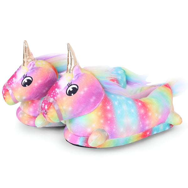 Une paire de pantoufles licorne en peluche arc-en-ciel avec une corne dorée et une queue arc-en-ciel.