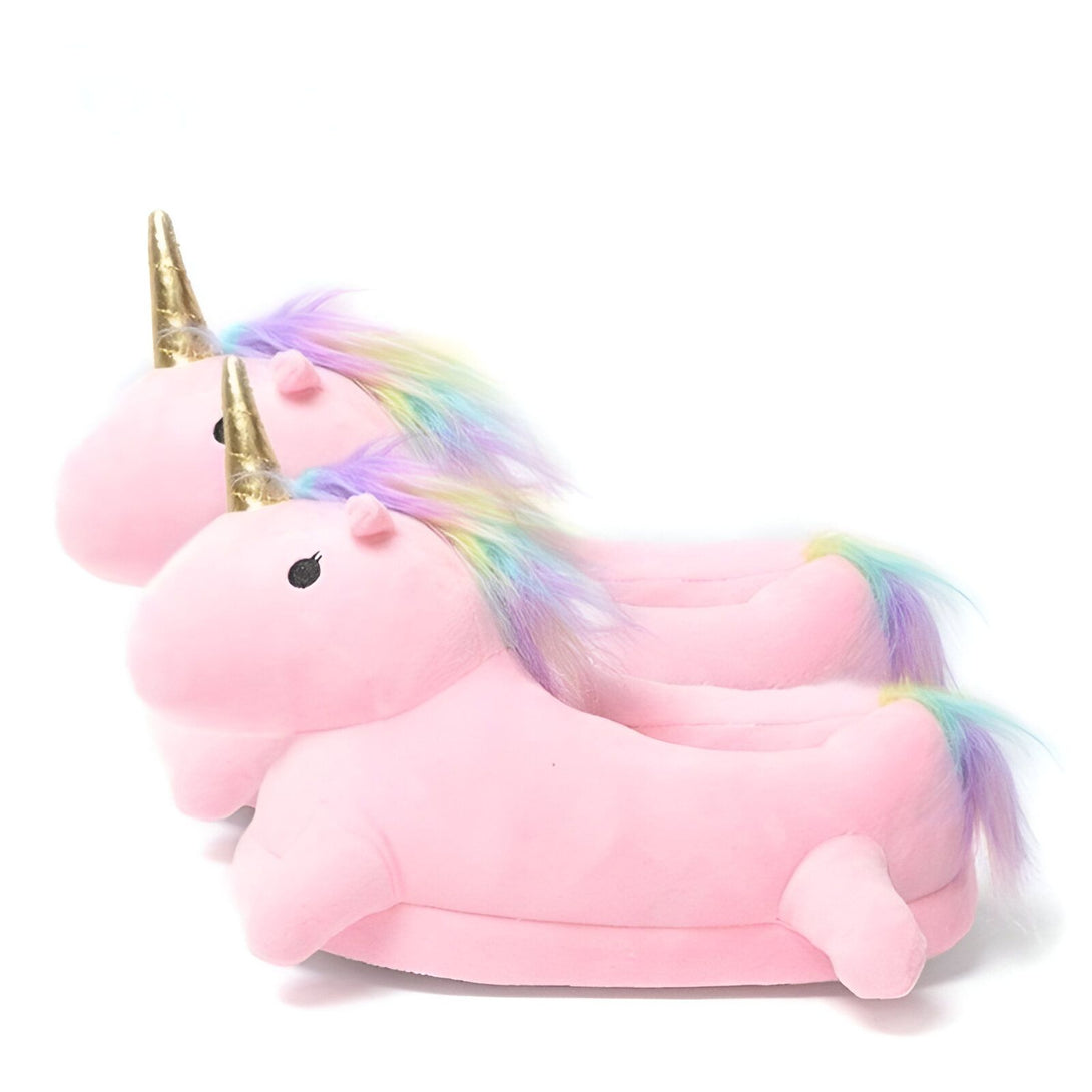 Une paire de pantoufles licorne en peluche rose avec une corne dorée et une crinière arc-en-ciel.