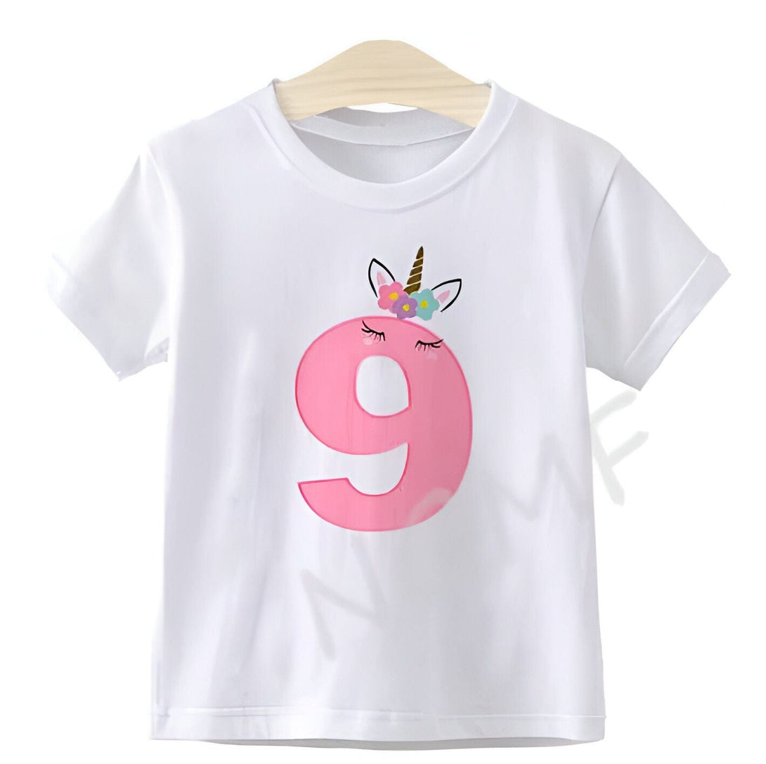 T-shirt blanc pour enfant, décoré d'un grand chiffre 9 rose orné d'un motif licorne avec des fleurs, suspendu à un cintre en bois. Idéal pour un anniversaire de 9 ans., 45502332141823,45502332174591,45502332207359,45502332240127,45502332272895,45502332305663,45502332338431,45502332371199 | Licorne Shop